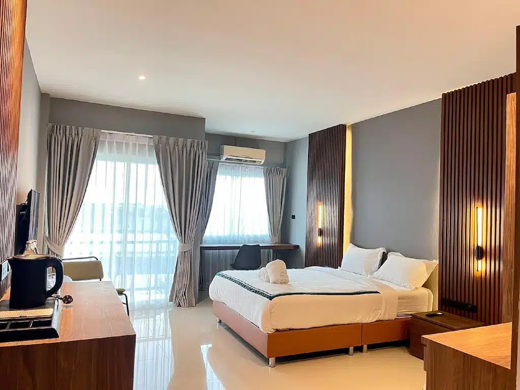 ห้องพักในโรงแรมที่มีเตียง โต๊ะ และโทรทัศน์ เที่ยวปราจีนบุรี