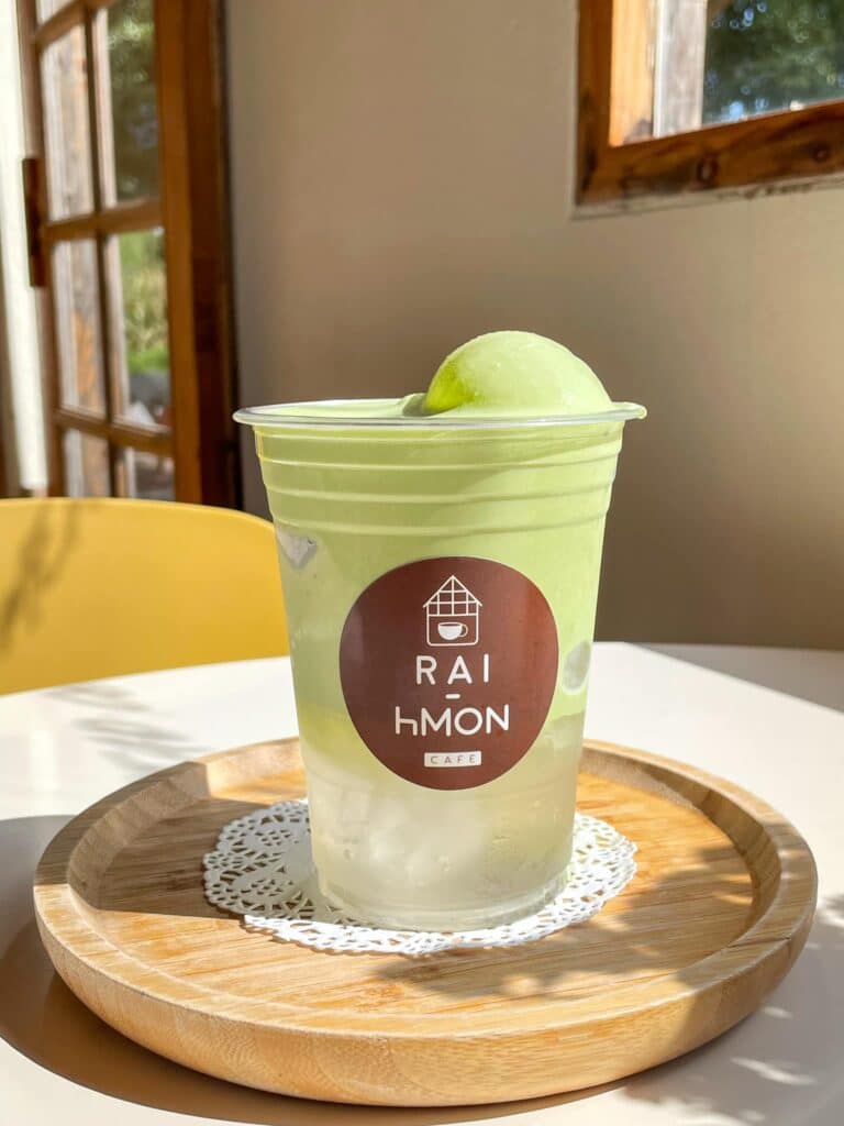ไอศกรีมสีเขียวถ้วยหนึ่งนั่งอยู่บนโต๊ะไม้ภูลมโล ภูลมโล 