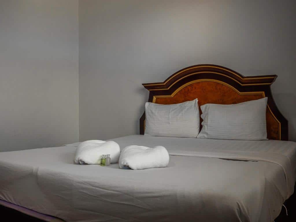 เตียงนอนที่มีผ้าเช็ดตัวสีขาว 2 ผืนวางทับอยู่ที่ รีสอร์ทปัตตานี