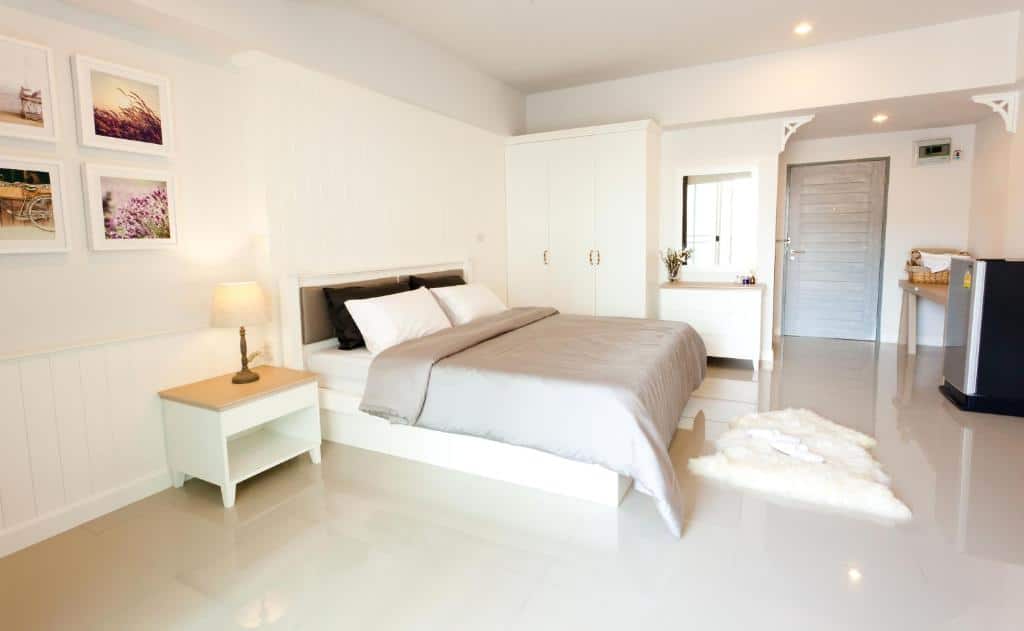 ห้องนอนสีขาวพร้อมเตียงและโต๊ะ ที่พักสมุทรสาคร