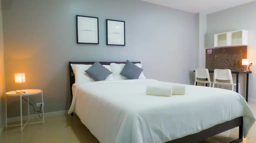 ห้องนอนเล็กๆ พร้อมเตียงสีขาวและผ้าเช็ดตัวสีขาวใน โรงแรมปัตตานี