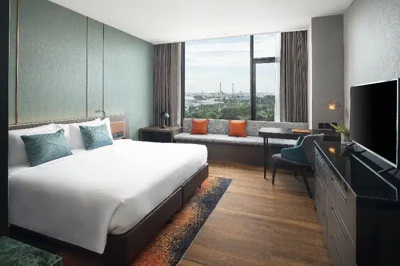 ห้องพักในโรงแรมที่มีเตียงขนาดใหญ่และวิวเมืองที่มองเห็นลำธารชลมารควิถี สะพานชลมารควิถี
