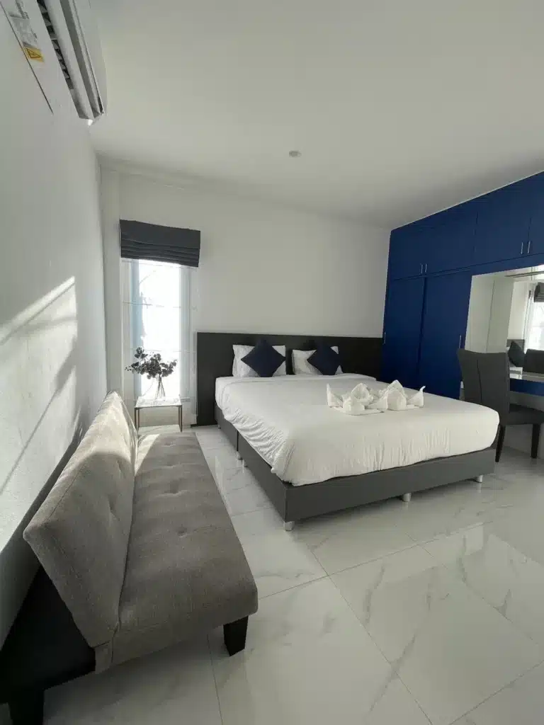 ห้องนอนสีฟ้าขาวพร้อมเตียงและโซฟาที่โรงแรมแห่งหนึ่งในจังหวัดร้อยเอ็ด โรงแรมร้อยเอ็ด