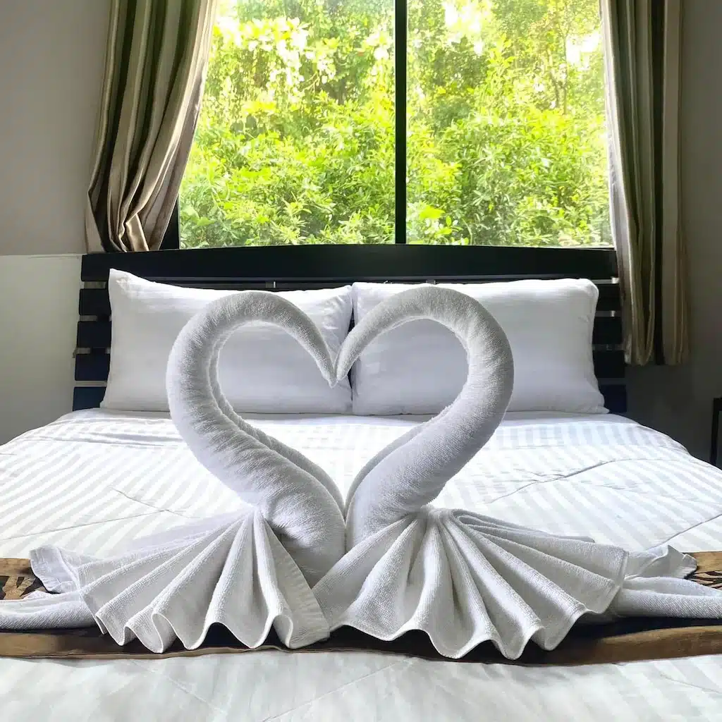 หงส์สองตัวทำจากผ้าเช็ดตัวบนเตียงที่โรงแรมปทุมธานี ที่พักปทุมธานี