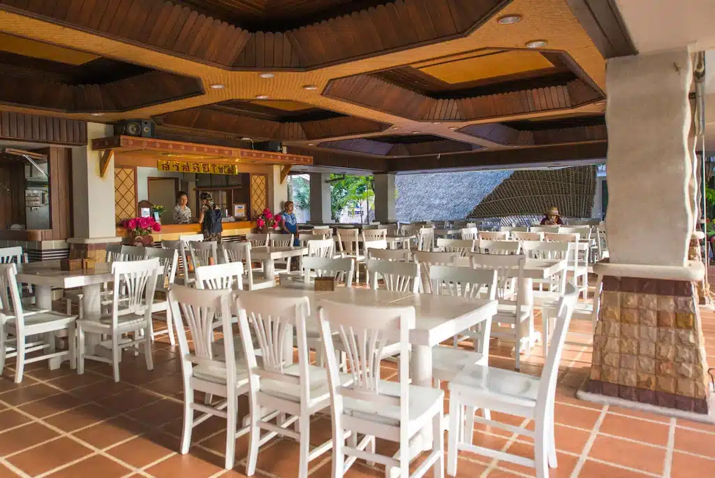 ที่พักตรังติดทะเล ร้านอาหารริมชายหาดพร้อมโต๊ะและเก้าอี้สีขาว
