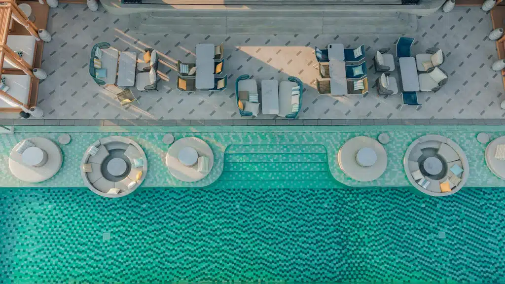 มุมมองทางอากาศของสระว่ายน้ำและเก้าอี้เลานจ์ที่โรงแรมแห่งหนึ่งในจังหวัดนครราชสีมา โรงแรมนครราชสีมา