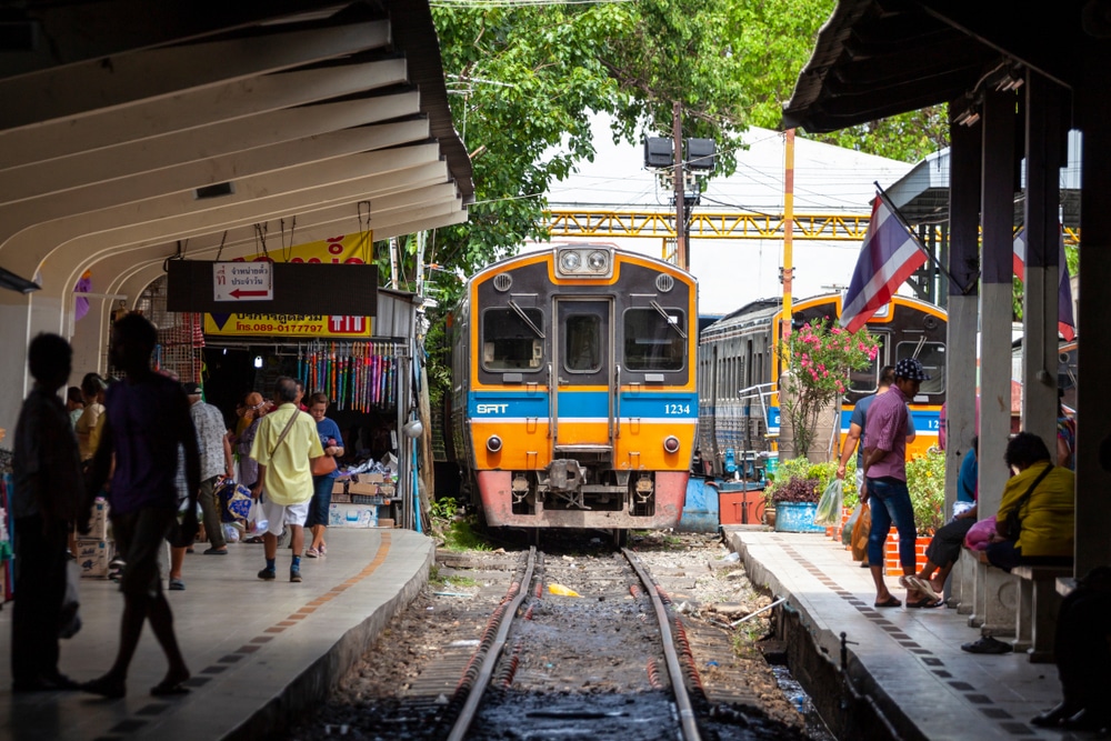 รถไฟเป็นสีน้ำเงินเหลืองเดินทางไปยังจุดหมายปลายทางที่สวยงามในจังหวัดราชบุรี ที่เที่ยวสมุทรสาคร