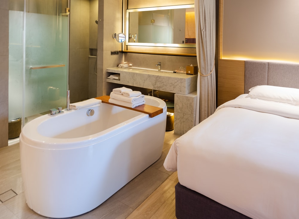 ห้องพักโรงแรมในนครราชสีมาพร้อมอ่างอาบน้ำและเตียงนอน โรงแรมนครราชสีมา
