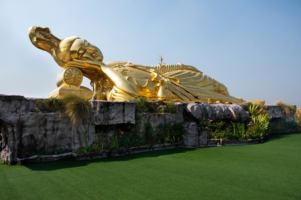 พระพุทธรูปทองคำนั่งบนพื้นหญ้าที่ วัดนครปฐม