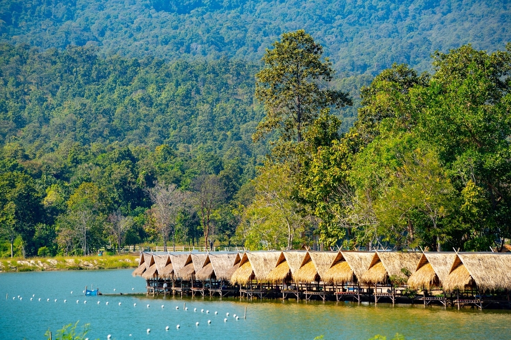 กลุ่มกระท่อมที่ตั้งอยู่บนชายฝั่งอันเงียบสงบของทะเลสาบที่งดงามในประเทศไทย ห้วยตึงเฒ่า