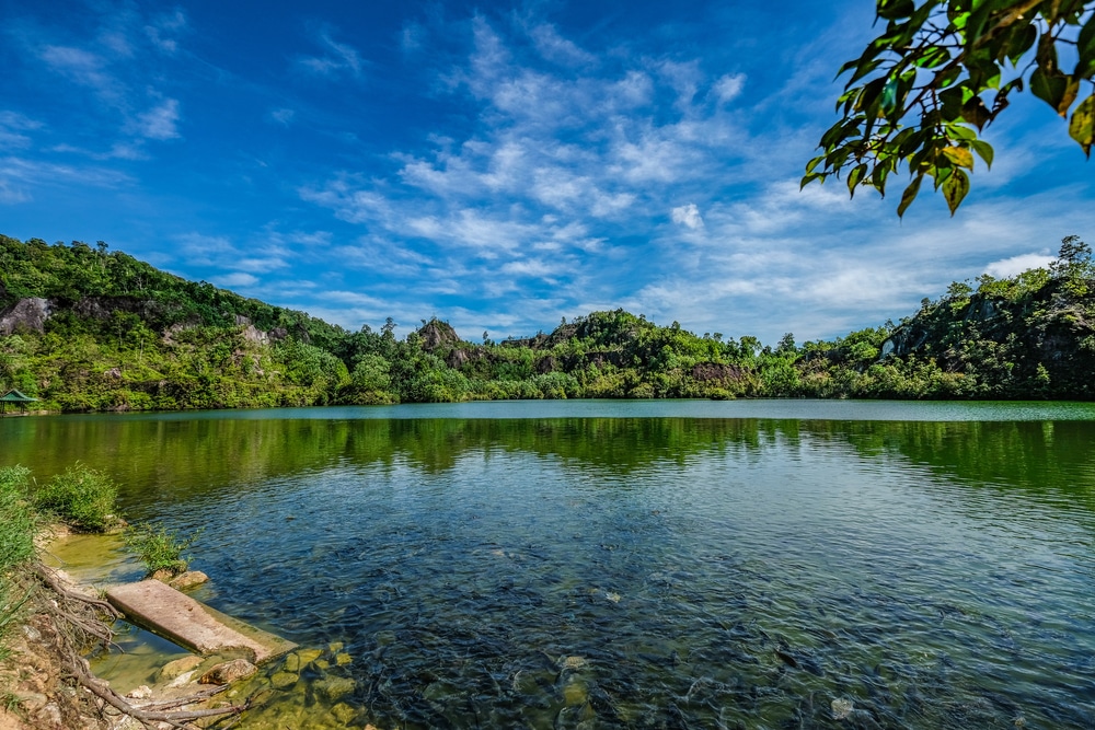 ทะเลสาบที่ล้อมรอบด้วยต้นไม้และท้องฟ้าสีคราม ที่เที่ยวระนอง