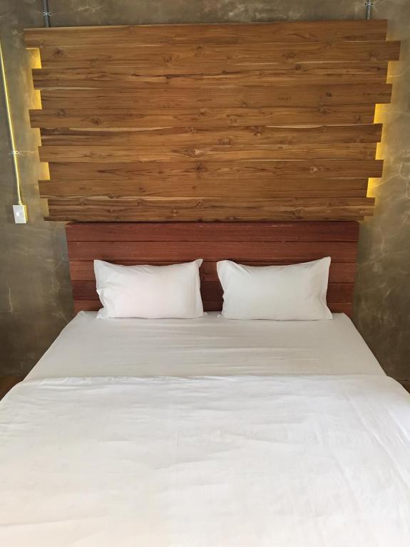 เตียงในห้องที่มีหัวเตียงไม้ โรงแรมน่าน
