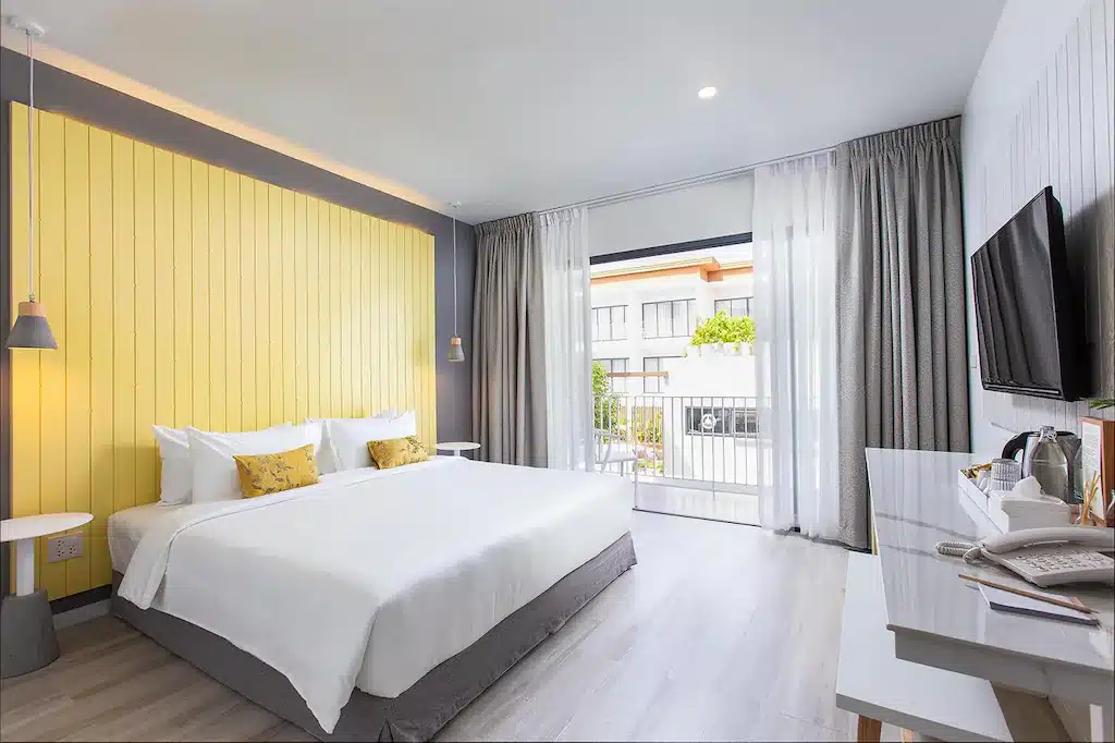 ห้องพักในโรงแรมที่เน้นสีเหลืองและเตียง ได้รับแรงบันดาลใจจากบ้านไร่ไออรุณ