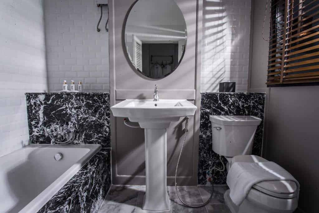 ห้องน้ำขาวดำพร้อมโถส้วมและอ่างล้างหน้า ตั้งอยู่ในที่พักราคาถูกในอ่าวนาง โรงแรมอุดรธานี