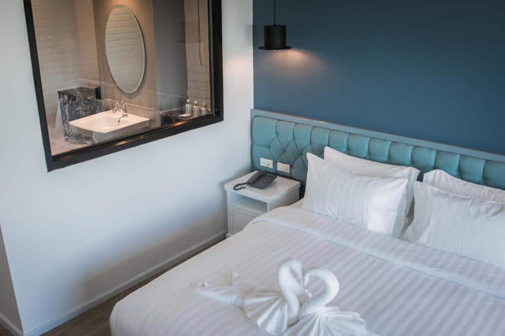 เตียงในห้องที่มีผนังสีฟ้าและกระจกที่อ่าวนาง โรงแรมอุดรธานี