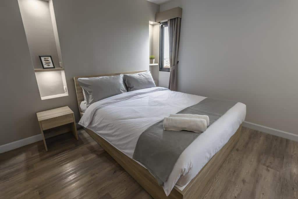 ห้องนอนเรียบง่ายพร้อมพื้นไม้อบอุ่นและเตียงสีขาวแสนสบาย ที่พักสมุทรปราการ