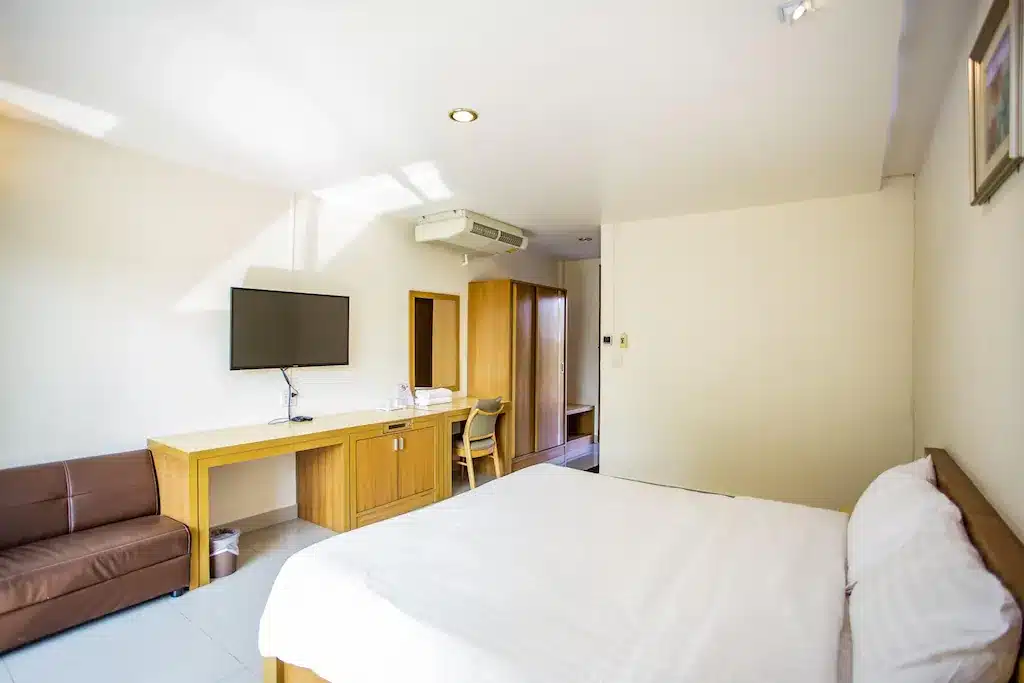 ห้องพักในโรงแรมที่ ที่พักสิงห์บุรี มีเตียง โต๊ะ และทีวี ในเที่ยวชัยนาท