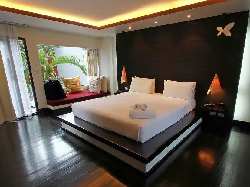 ห้องนอนปูพื้นไม้และเตียงขนาดใหญ่ ขนอมพูลวิลล่า