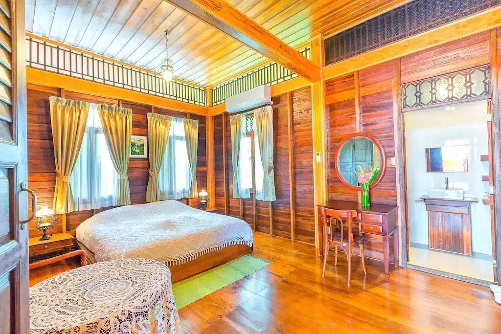 ห้องนอนธรรมชาติพร้อมผนังไม้และพื้นไม้ในที่พักริมแม่น้ำในจังหวัดราชบุรี โรงแรมในราชบุรี