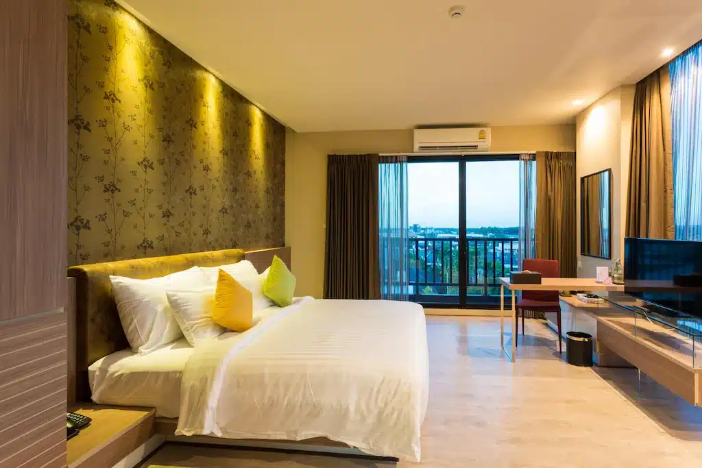 ห้องพักในโรงแรมที่มีเตียงขนาดใหญ่และโทรทัศน์ เหมาะสำหรับนักท่องเที่ยวที่มาเยือนราชบุรีที่เที่ยวหรือท่องเที่ยวรา ที่เที่ยวหาดใหญ่
