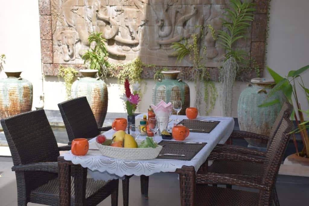 โต๊ะหวายประดับด้วยผลไม้สีสันสดใสและดอกไม้บาน ที่พักสิงห์บุรี ช่วยสร้างการจัดแสดงที่มีชีวิตชีวา