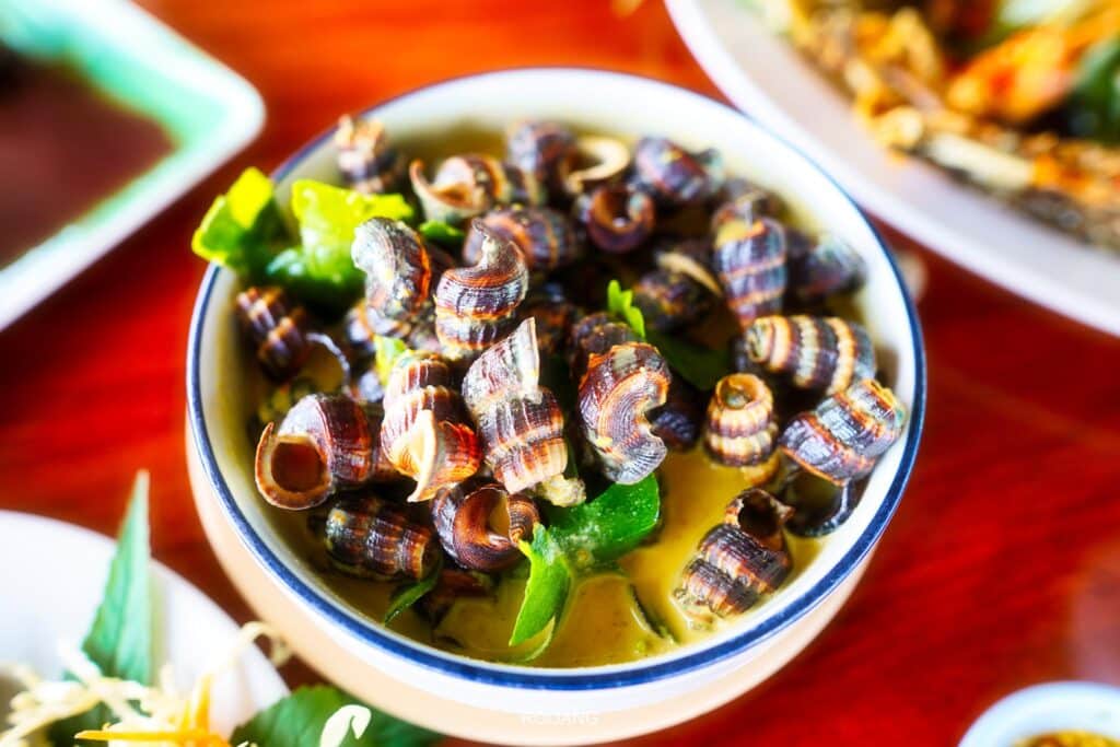 ชามหอยและอาหารอื่นๆ จุดชมวิวเสม็ดนางชี บนโต๊ะในราชบุรีที่เที่ยว