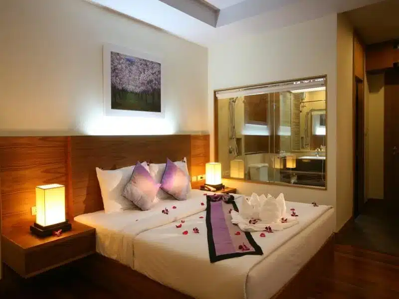 ห้องพักที่มีพื้นไม้และเตียงประดับด้วยดอกไม้ เหมาะสำห เกาะช้างที่พัก บการพักผ่อนและการพักผ่อนอันเงียบสงบ