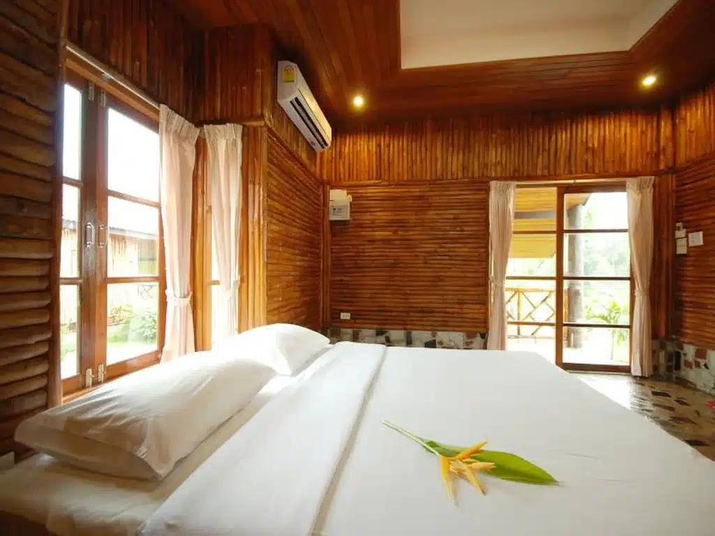 เตียงในห้องที่มีผนังไม้ตั้งอยู่ใกล้ทะเล โรงแรมตราด