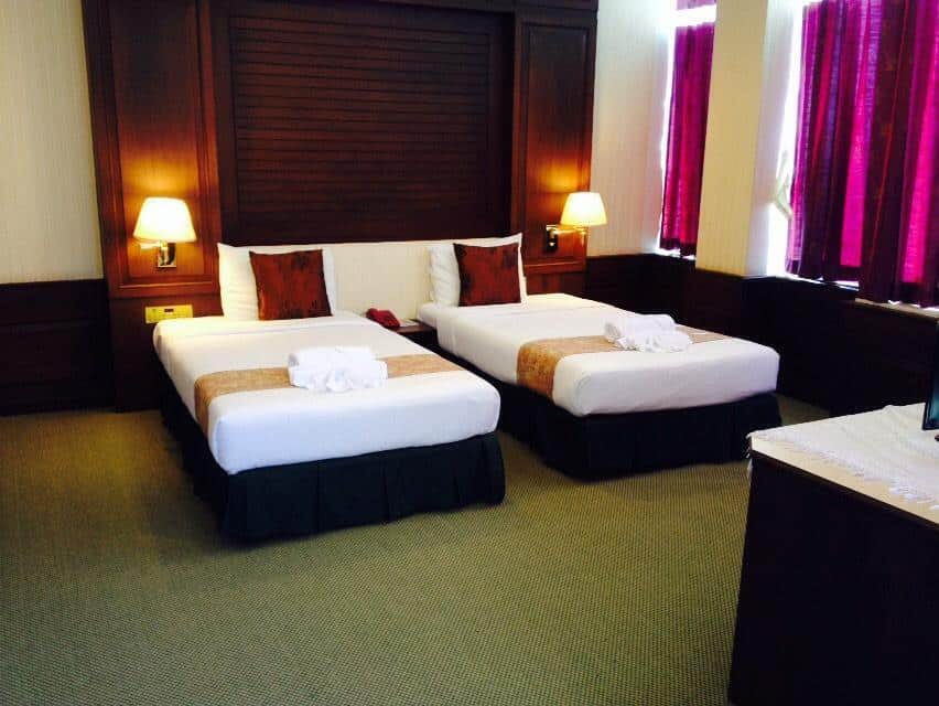 เตียงสองเตียงในห้องพักโรงแรมในเที่ยวราชบุรีพร้อมผ้าเช็ดตัว ที่เที่ยวชัยนาท