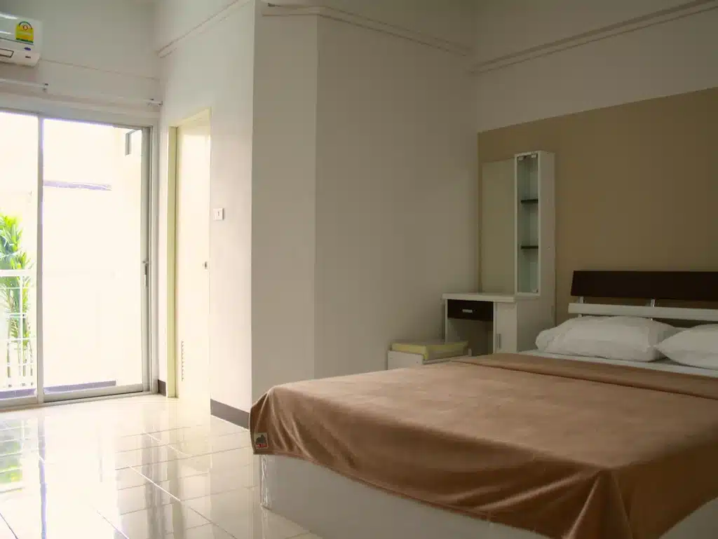 ห้องที่มีเตียงและประตูกระจกบานเลื่อน รีสอร์ทสิงห์บุรี
