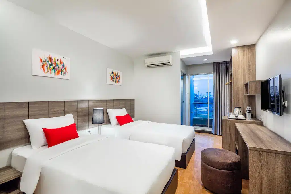 ห้องพักในโรงแรมที่มีเตียงสองเตียงและโทรทัศน์เหมาะสำหรับนักท่องเที่ยวที่มาเยือนราชบุรี โรงแรมในกรุงเทพ