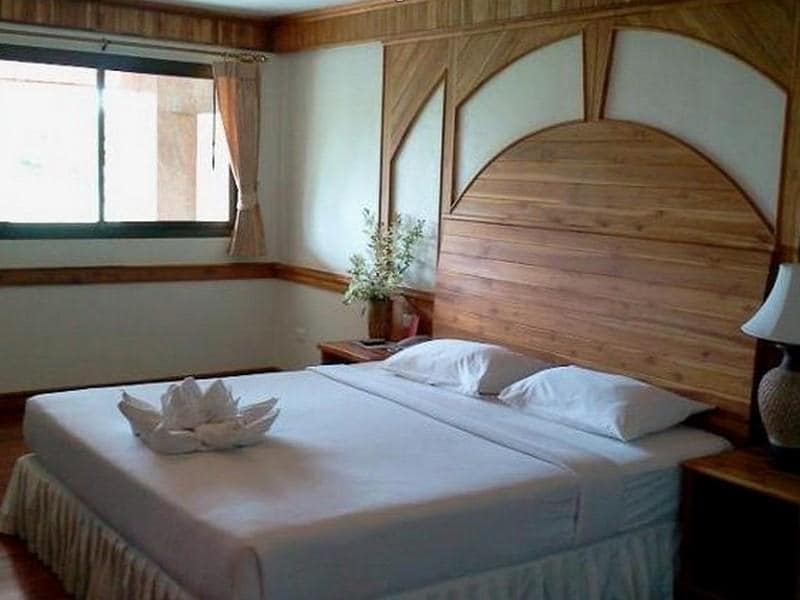 ห้องที่มีเตียงไม้และหน้าต่างในราชบุรีที่เที่ยว  โรงแรมเกาะช้าง