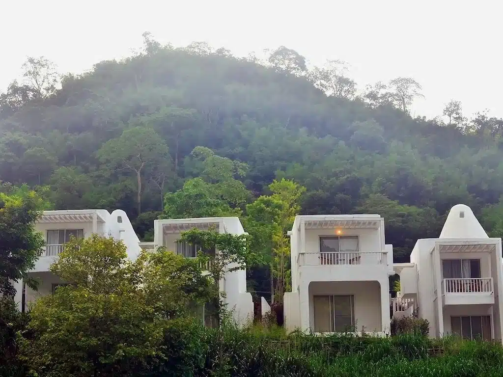 กลุ่มอาคารสีขาวบนเนินเขาติดกับป่า เป็นทางเลือกที่พักอันเงียบสงบและเป็นธรรมชาติในราชบุรี ที่พักริมน้ำราชบุรี