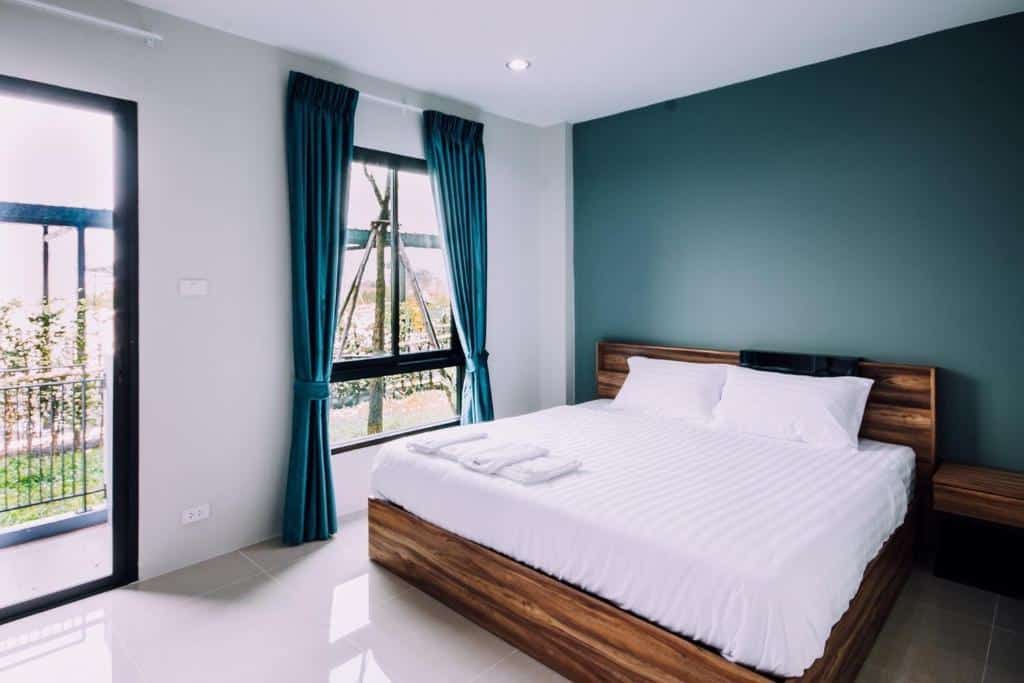 ห้องนอนแสนสบายพร้อมเตียงสีขาวและผนังสีฟ้า โรงแรมสมุทรปราการ