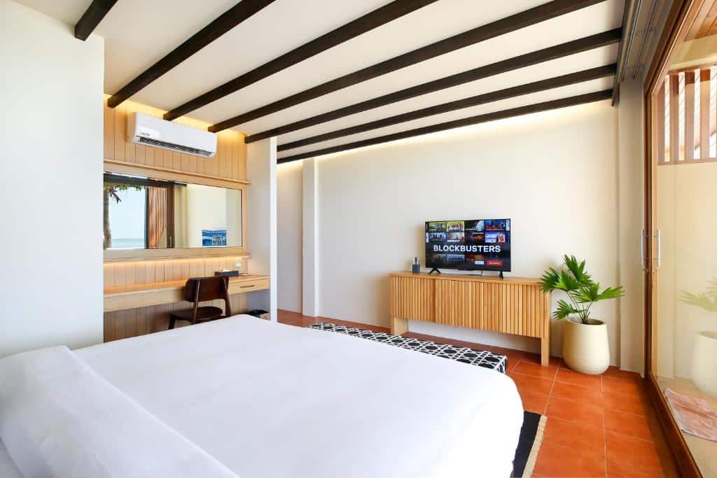 ห้องพักพร้อมเตียง โต๊ะ และทีวี ในแหล่งท่องเที่ยวที่สวยงามของราชบุรี เกาะเต่าที่พัก