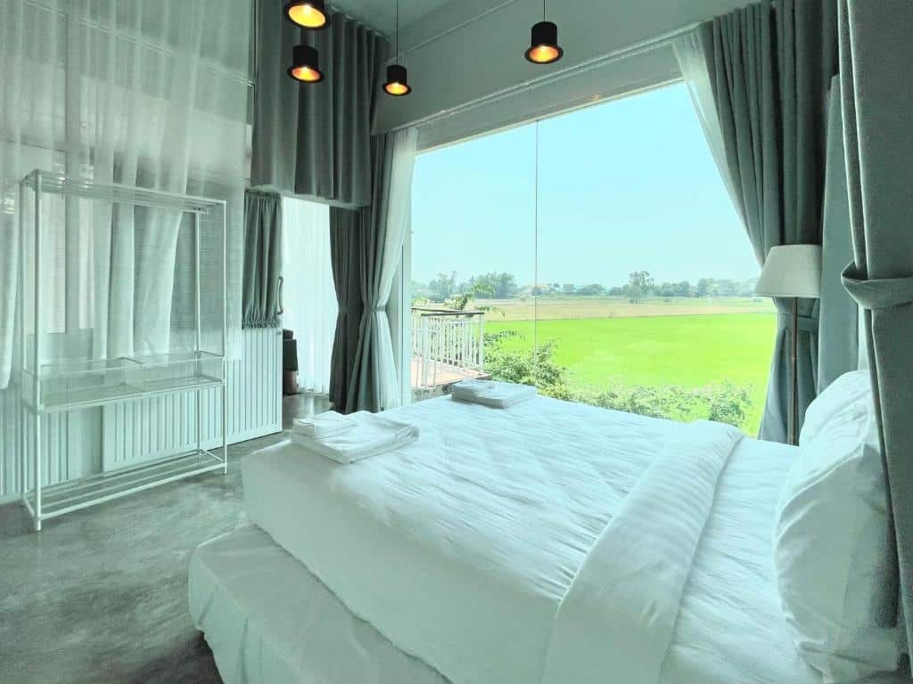 เตียงในห้องพร้อมวิวทุ่งนา ที่พักสิงห์บุรี ในราชบุรีที่เที่ยว