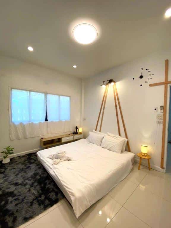 ห้องนอนพร้อมเตียงและโต๊ะข้างเตียงในที่เที่ยวชัยนาท ที่พักเกาะสีชัง