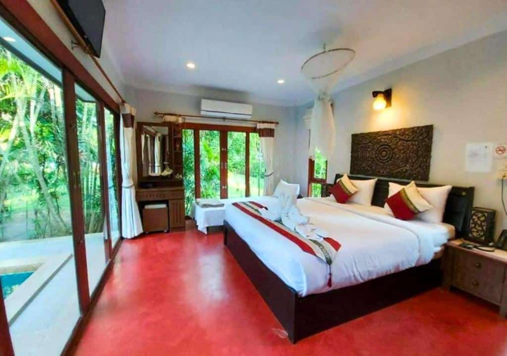 ห้องนอนที่มีพื้นสีแดงและประตูกระจกบานเลื่อน ขนอมพูลวิลล่า