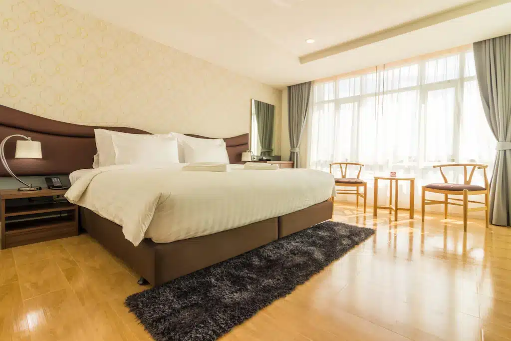 ห้องพักในโรงแรมที่มีพื้นไม้และเตียงขนาดใหญ่ ที่พักตราด