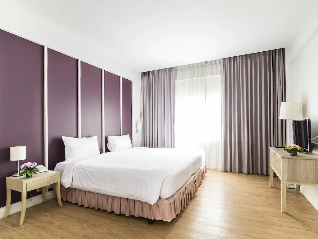 ห้องพักโรงแรมในราชบุ โรงแรมกรุงเทพ รีที่มีผนังสีม่วงและพื้นไม้