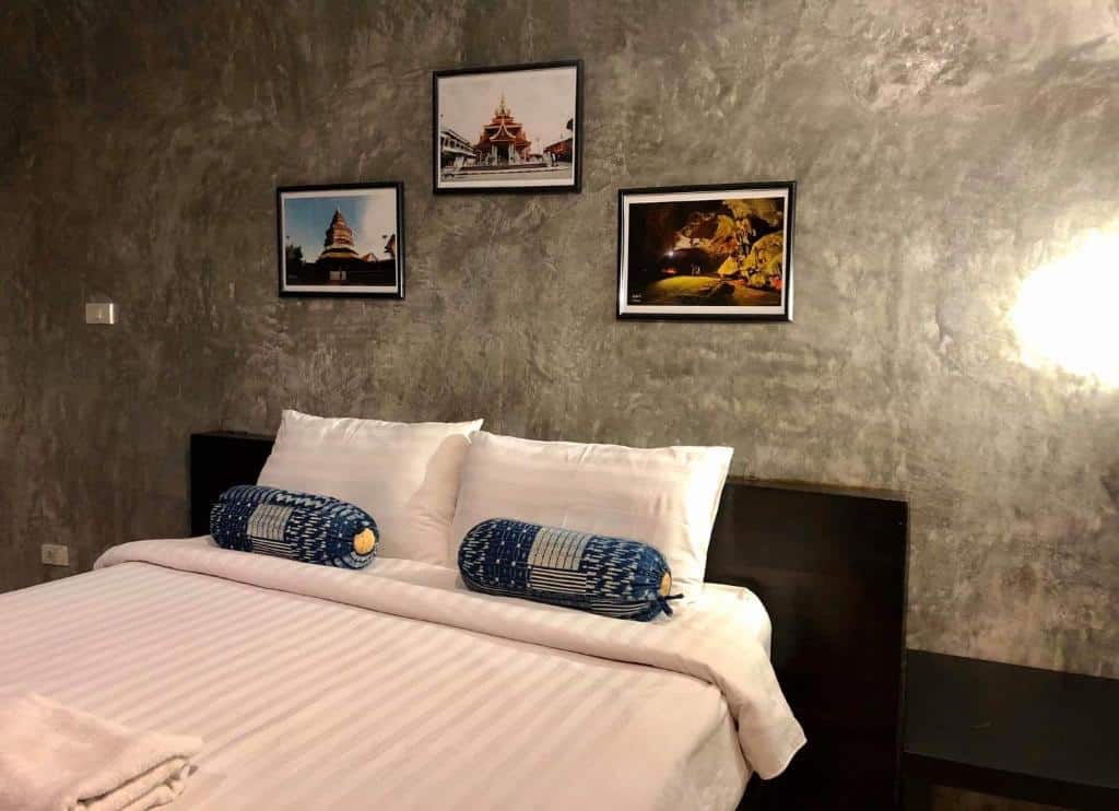 เตียงที่ได้แรงบันดาลใจจากธรรมชาติในห้องที่ประดับด้วยรูปภาพบนผนัง ที่พักแพร่ธรรมชาติ