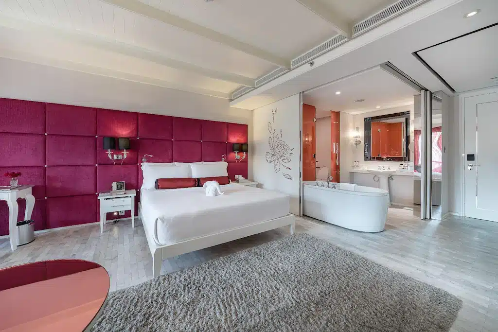 ห้องนอนผนังเน้นสีชมพูและเตียงสีขาวในเมืองราชบุรีที่สวยงาม โรงแรมในกรุงเทพ