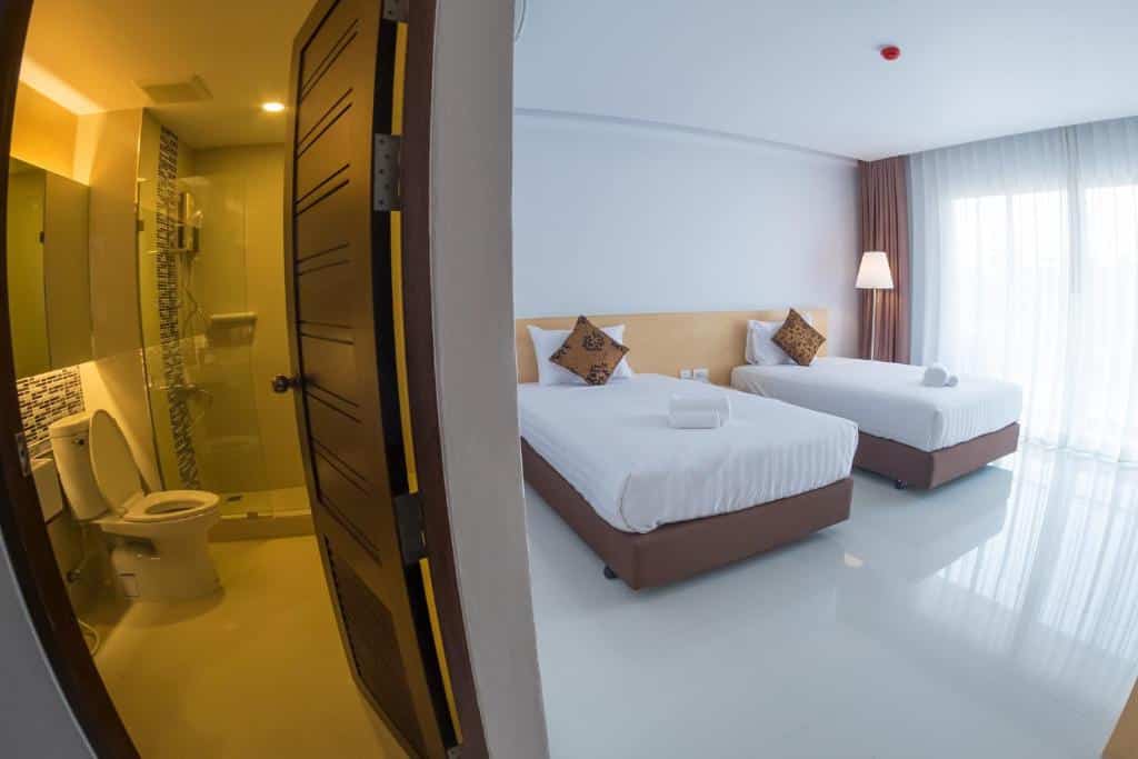 วิวห้องพักในโรงแรมที่มีเตียง 2 เตียงและห้องสุขา โรงแรมสิงห์บุรี