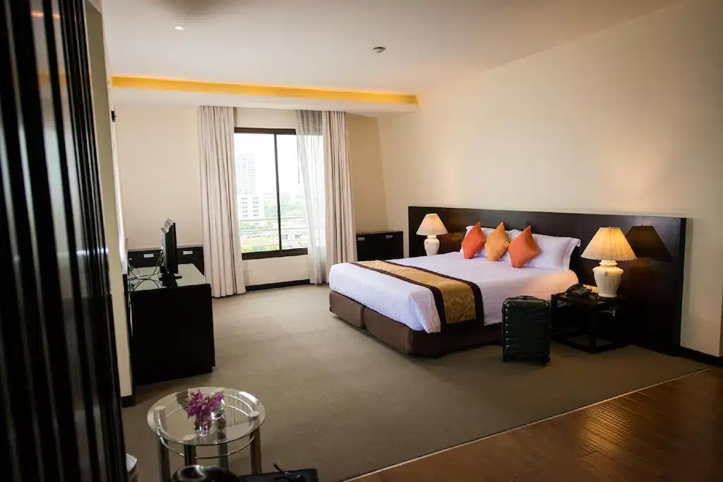 ห้องพักในโรงแรมพร้อมเตียงขนาดใหญ่และทีวีจอแบน เหมาะสำหรับการพักผ่อนใกล้สถานที่ท่องเที่ยวที่สวยงามของชัยนาทและราชบุรี ที่พักกรุงเทพ