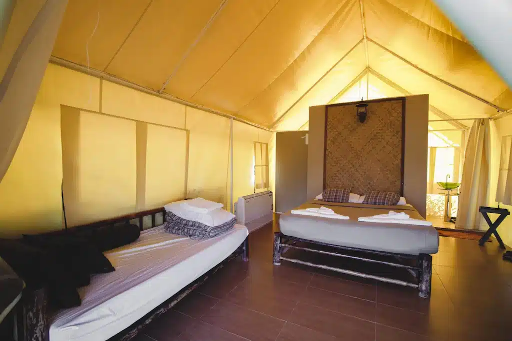 เตียงแสนสบายในเต็นท์ เหมาะสำหรับการพักผ่อนแบบผจญภัยในราชบุรีที่เที่ยวหรือเที่ยวราชบ เชียงคานที่เที่ยว