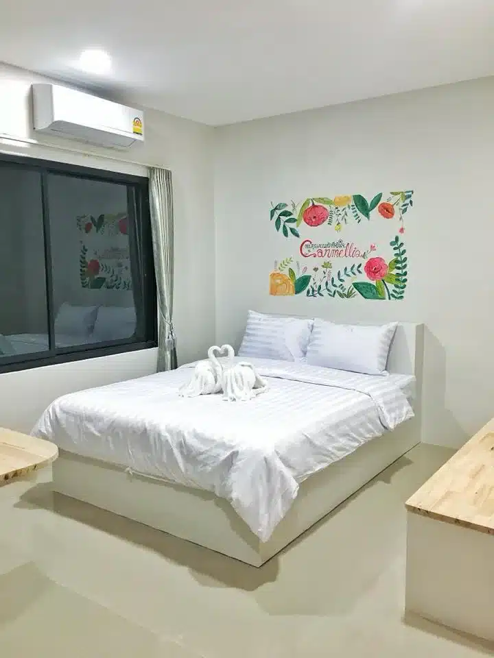 ห้องนอนสีขาวพร้อมเตียงที่มองเห็นแม่น้ำอันเงียบสงบในจังหวัดราชบุรี ประเทศไทย โรงแรมในราชบุรี
