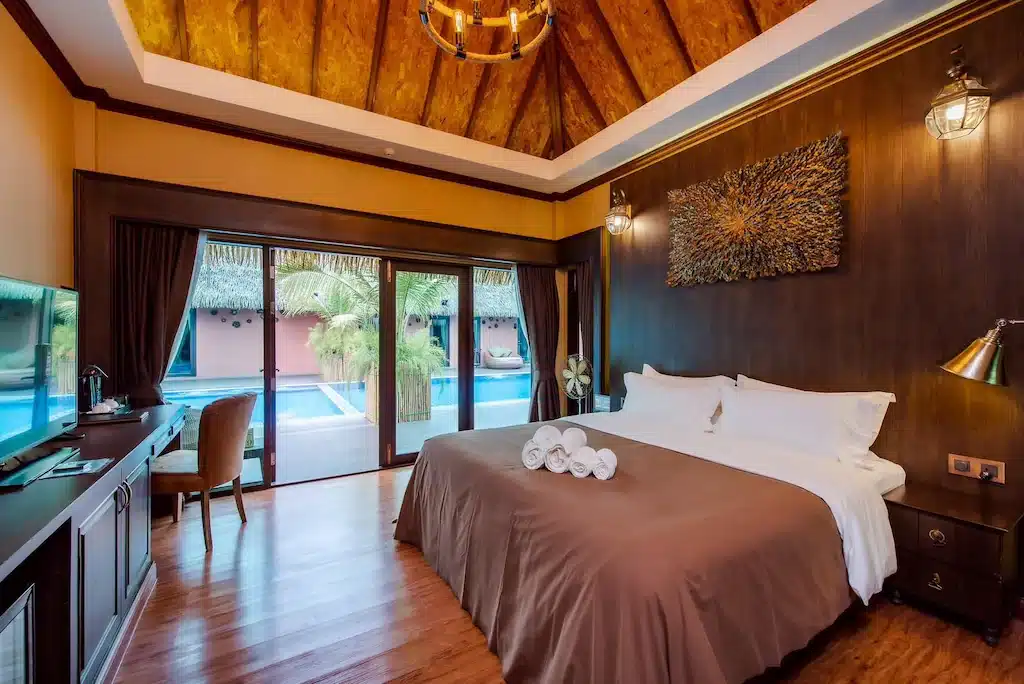 ห้องนอนแสนสบายพร้อมเพดานไม้ที่สวยงามและพื้นไม้อันอบอุ่น ที่พักราชบุรีริมน้ำ