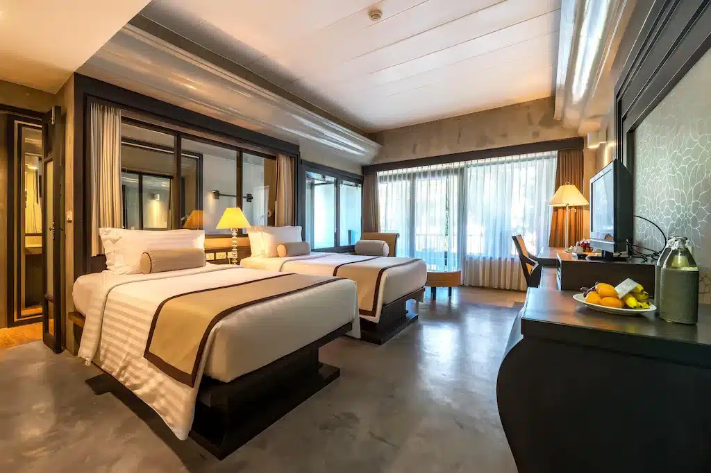 ห้องพักในโรงแรมที่มีเตียง 2 เตียงและโต๊ะทำงานในอุทยานราชบุรี ที่พักเกาะช้าง