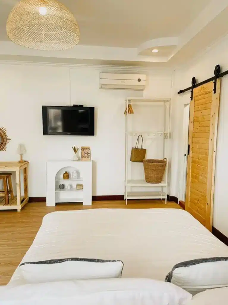 ห้องนอนพร้อมเตียงและทีวี ที่พักเกาะสีชัง ในสถานที่ท่องเที่ยวราชบุรีประเทศไทย