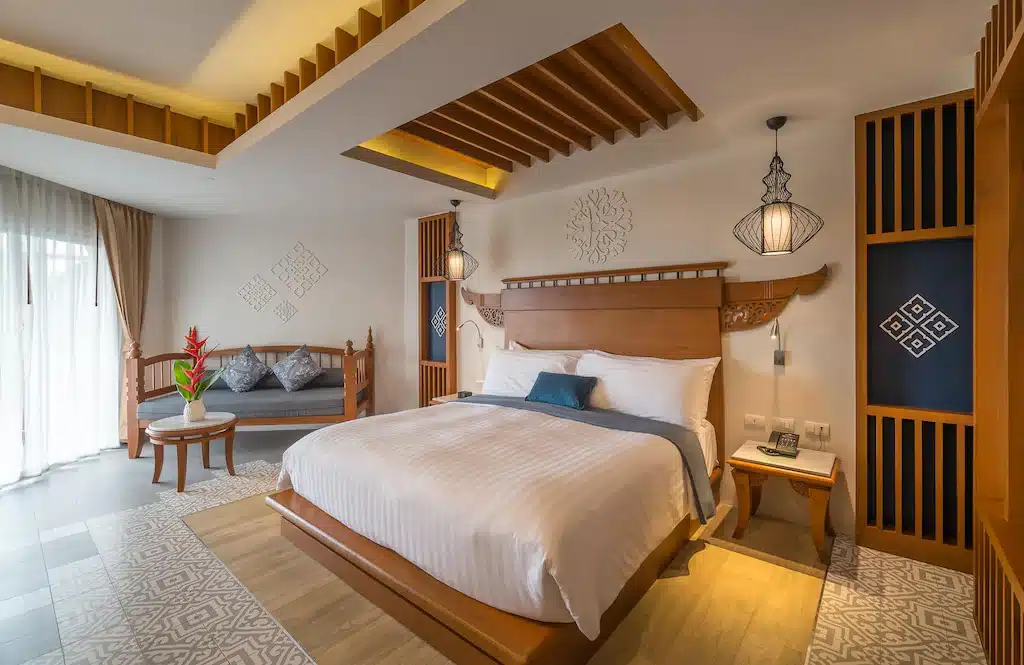 ห้องนอนพร้อมเตียงขนาดใหญ่และหัวเตียงไม้ในที่พักริมทะเลในอ่าวนาง กระบี่ ที่พักอ่าวนางติดทะเล